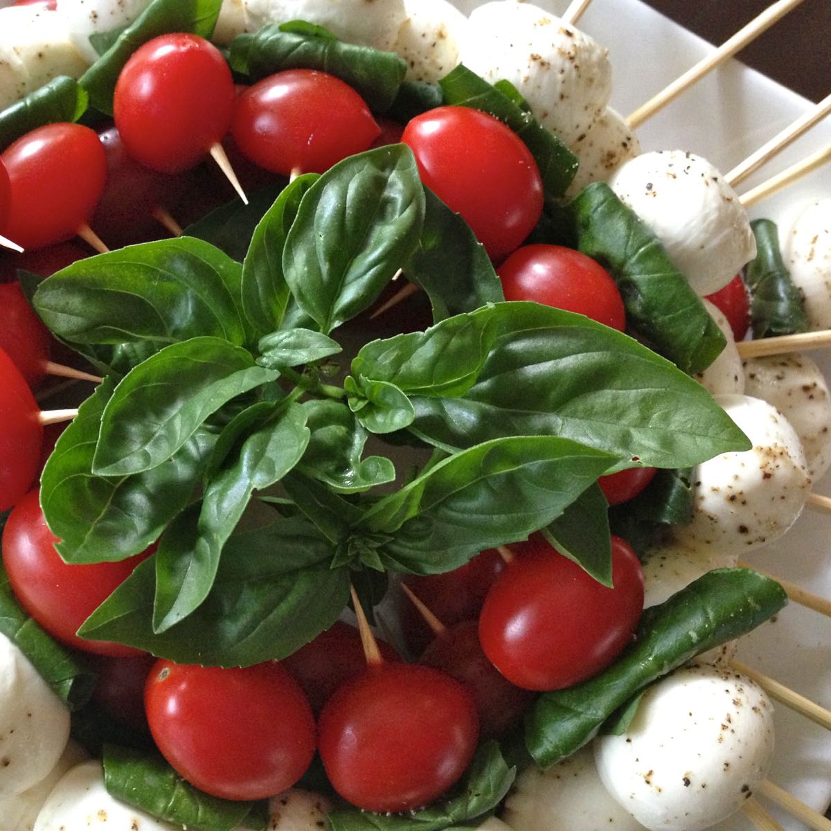 A wreath made of cherry tomatoes, bocconcini and fresh basil