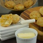 Gluten free Cheese Biscuits on a board served with a dish of butter on the side.