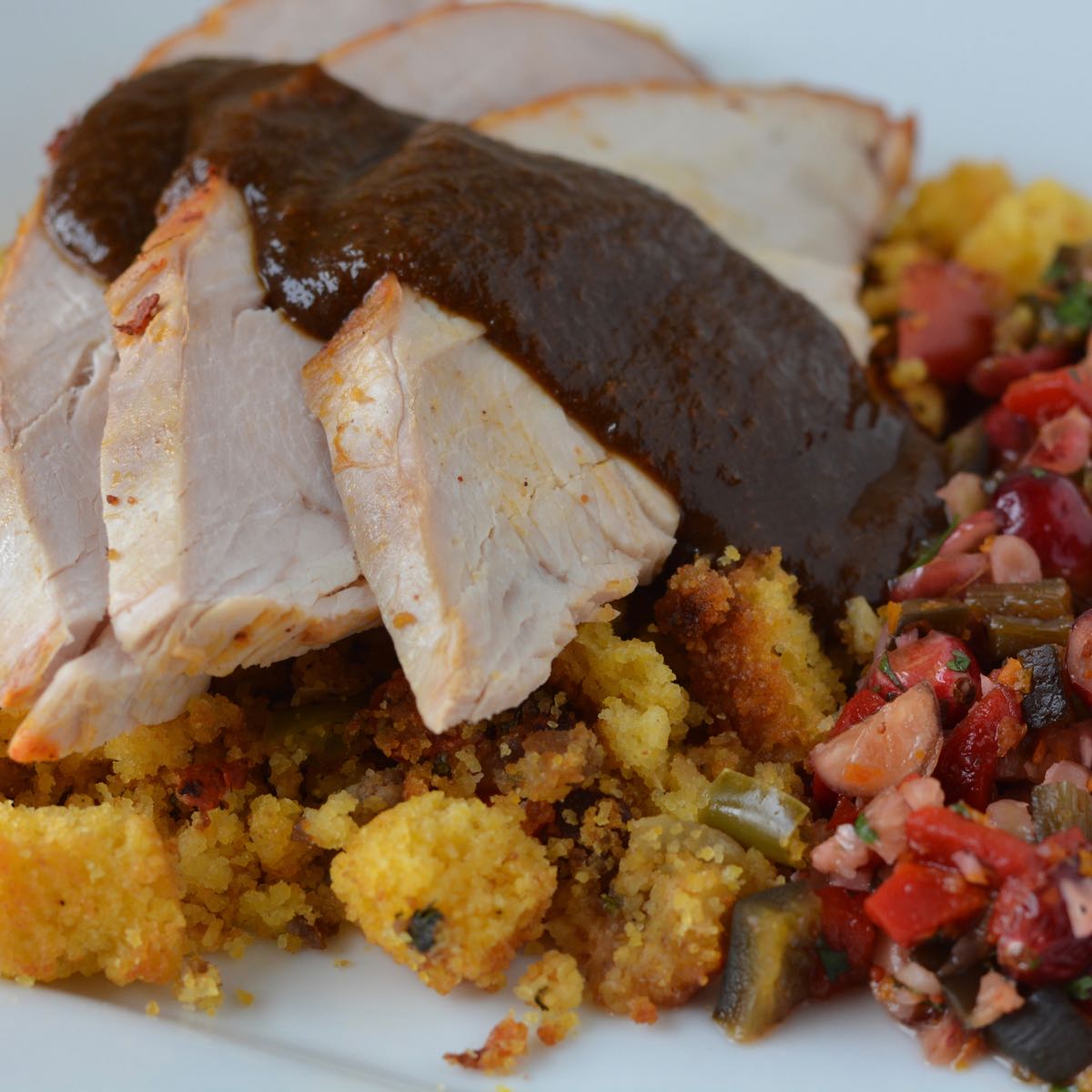 A plate of gluten free Cornbread Chorizo Stuffing topped with turkey slices.