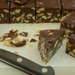 Eatmore bars on a cutting board being cut into thick diamond shapes.