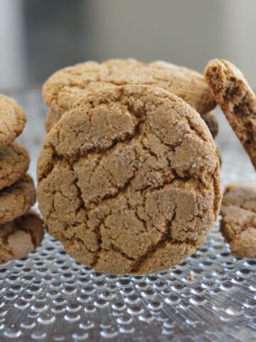 A stack of Molasses Ginger Cookies on a clear plate.