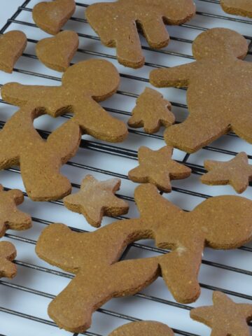 A cooling rack covered in gingerbread men, some with a heart shape space in the center.