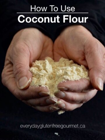 Black background with two hands full of coconut flour.
