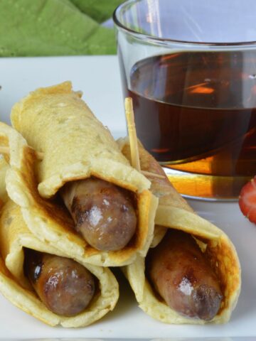 Three Pigs in a Blanket covered in syrup.
