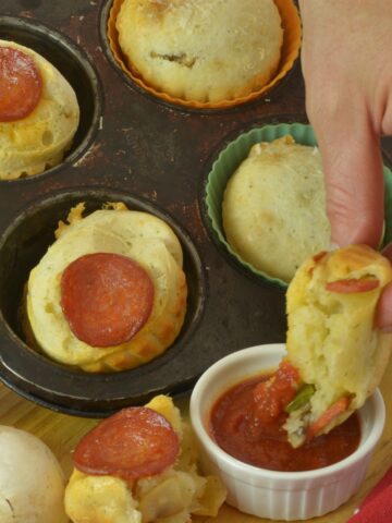 Pepperoni Pizza Cheese Buns in the pan surrounded by green pepper, mushrooms and pizza dipping sauce.