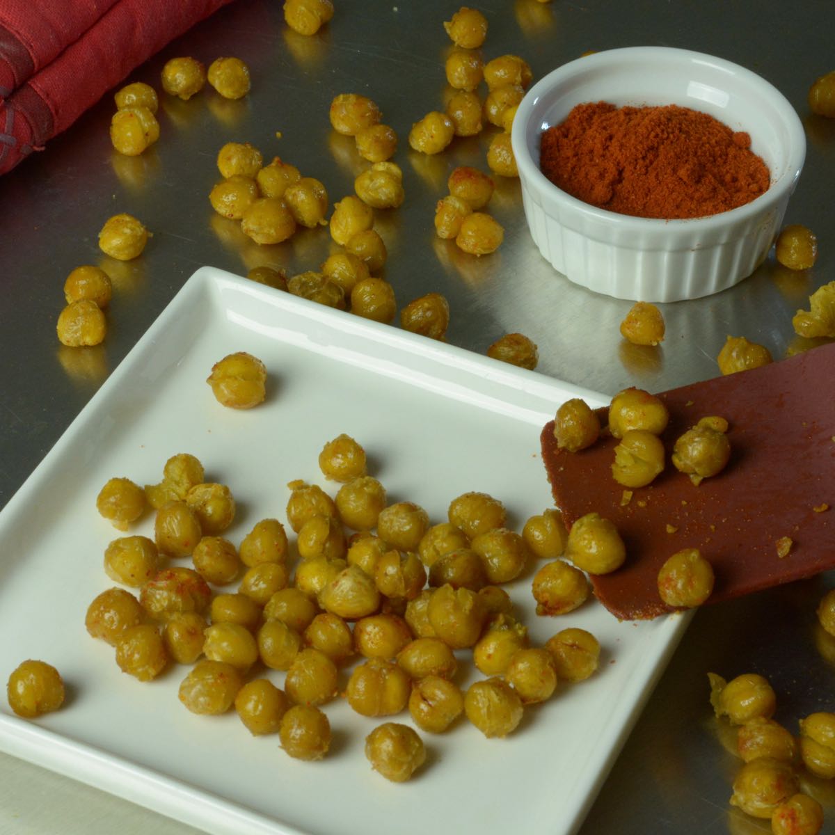 Roasted Chickpeas on a plate with a dish of paprika.