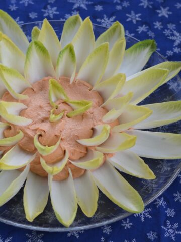 A platter with smoked salmon pate surrounded by Belgain endive leaves to look like a flower.