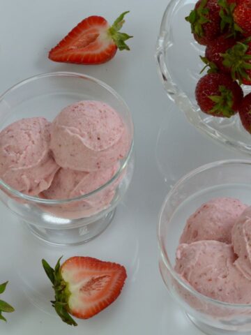 Dishes of Strawberry Cheesecake Ice Cream with fresh strawberries for garnish.