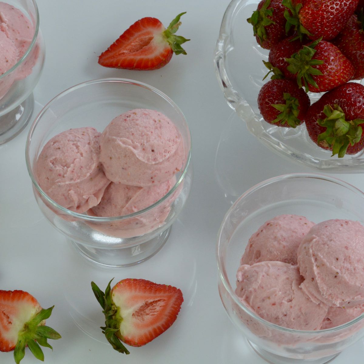 Dishes of Strawberry Cheesecake Ice Cream with fresh strawberries for garnish.