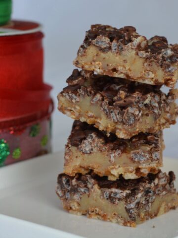 A stack of gluten free toffee squares with Christmas ribbon in the background.