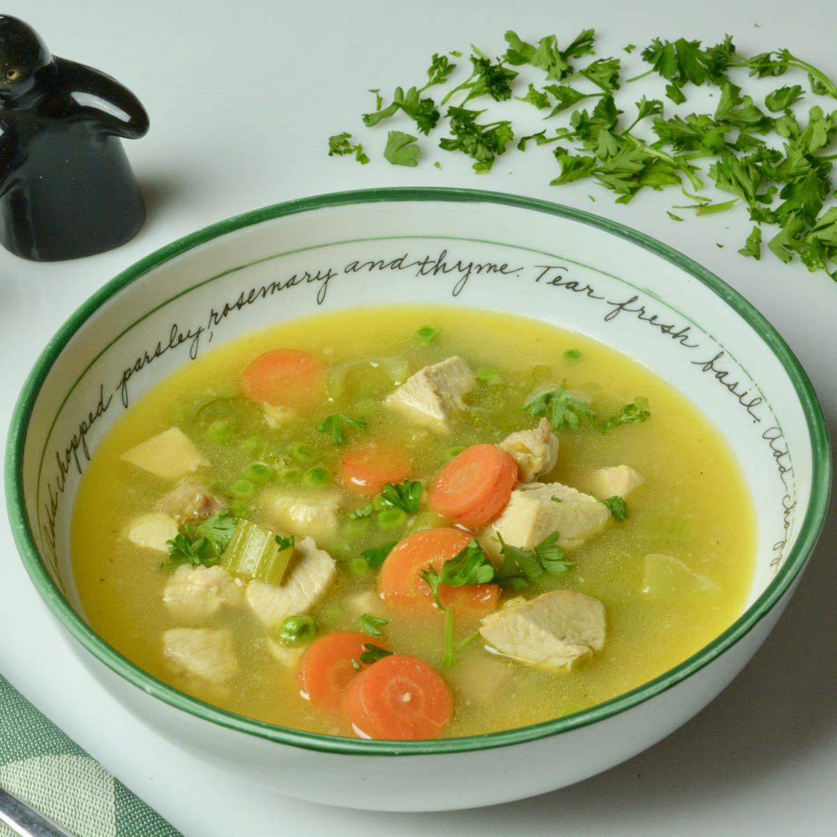 A full bowl of homemade Turkey Soup with carrots and peas.