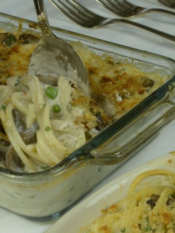 Turkey Tetrazzini being served up from a casserole dish.