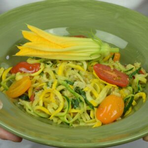 A bowl of Zucchini Noodles with Cherry Tomatoes, Basil and Parmesan Cheese.