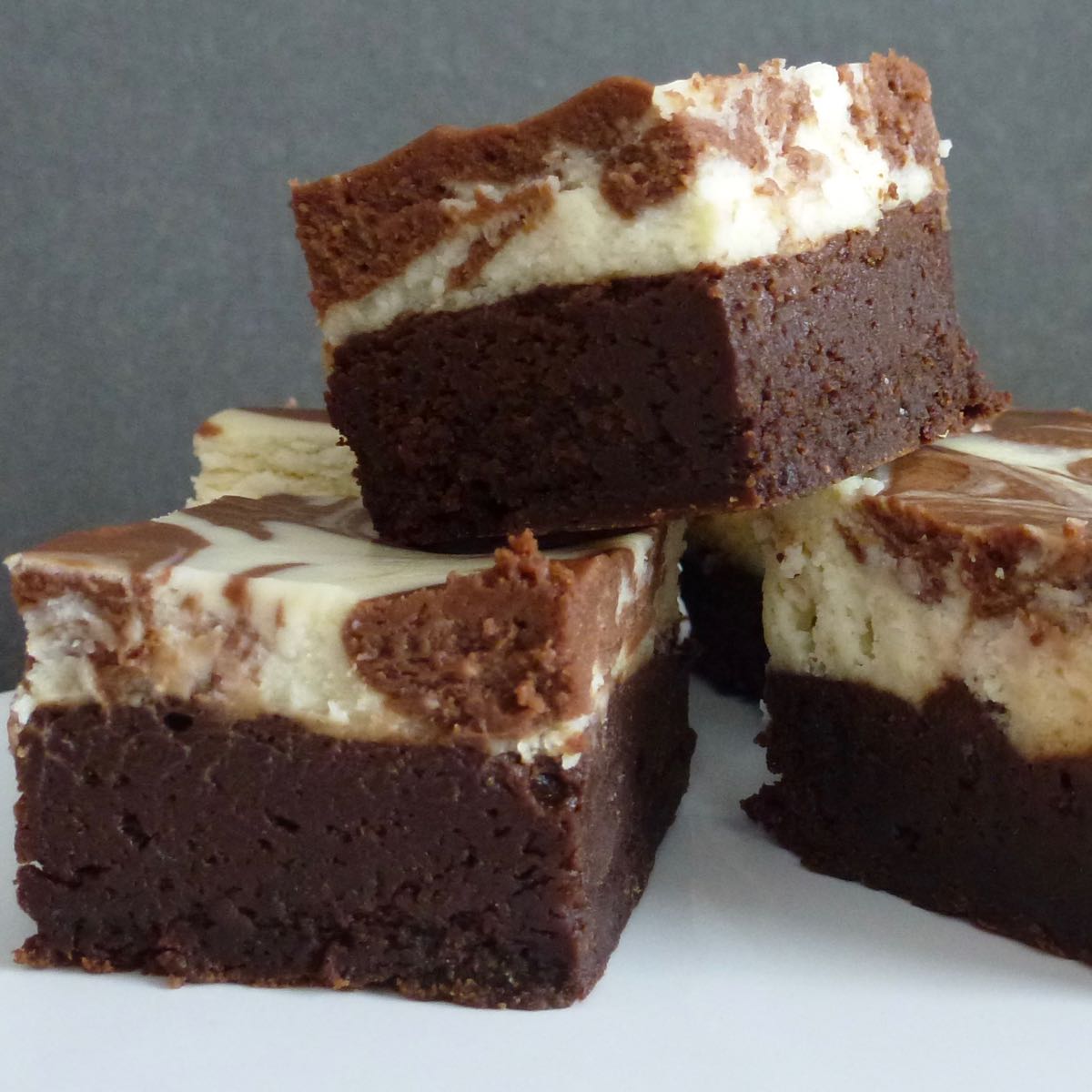 Three Gluten Free Chocolate Cheesecake Brownies cut with perfect edges.