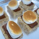 A tray with Gluten Free Rice Krispie Smores with lightly toasted marshmallows on top.