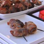 A plate with three Chorizo Stuffed Bacon Wrapped Dates.