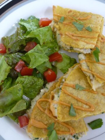 A plate with crab quesadillas with a drizzle of chipotle mayo