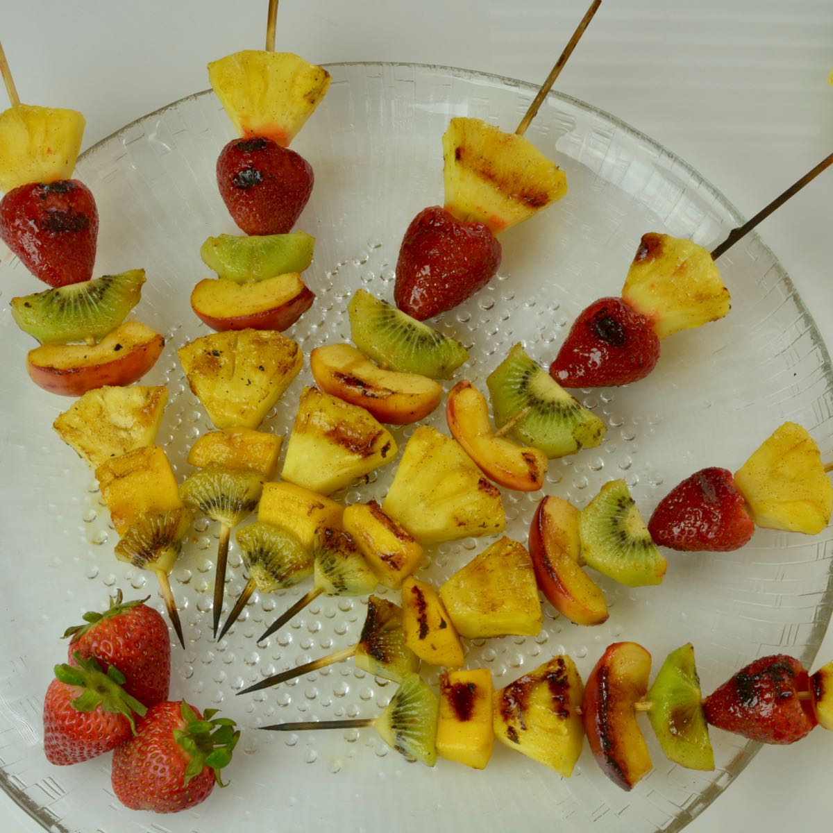 A platter of Grilled Fruit Skewers with Honey Cinnamon Glaze.