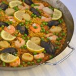 A paella pan filled with Paella with Seafood.