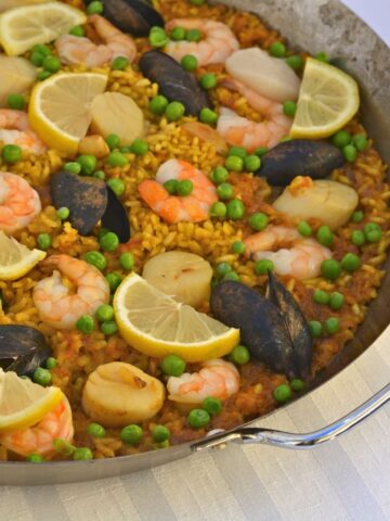 A paella pan filled with Paella with Seafood.
