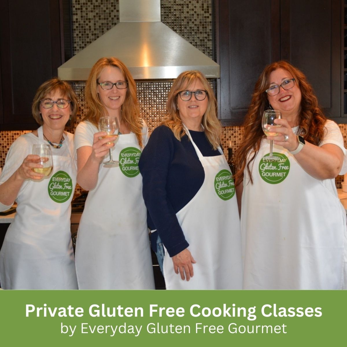 4 ladies wearing aprons in the Everyday Gluten Free Gourmet kitchen raising a glass of wine.