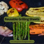A Reusable Grilling Sheet on the barbecue covered with cooked vegetables that all show nice grill marks.