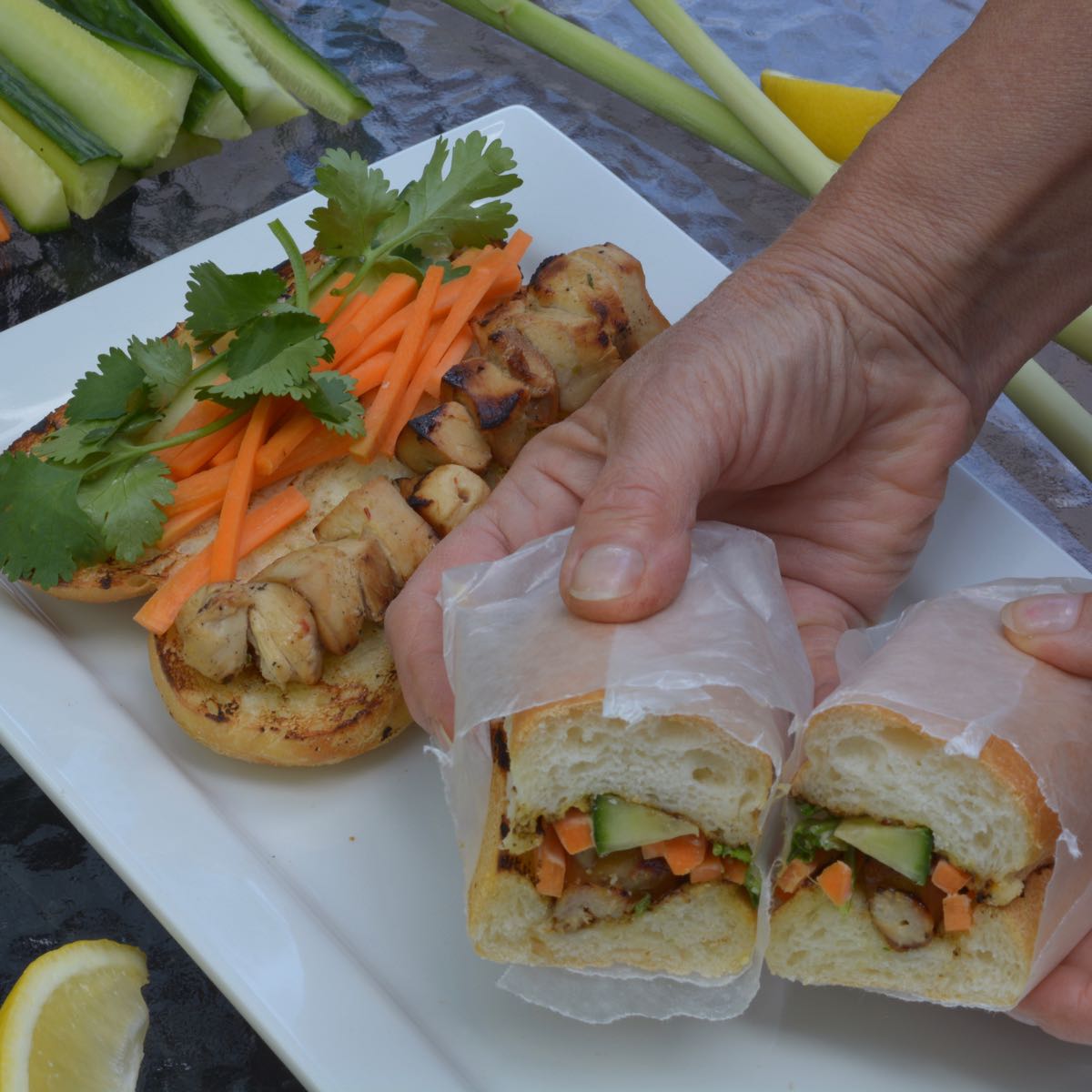 Two assembled Vietnamese Subs with Lemongrass Chicken, carrot, cucumber and cilantro