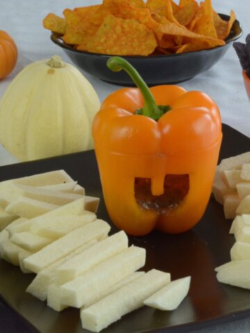 Black Bean Dip served in an orange pepper cut to look like a jack-o'-lantern.