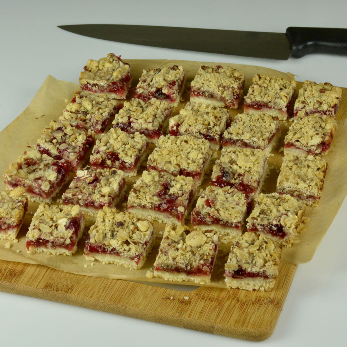 A board with cut gluten free Raspberry Crumble Bars.