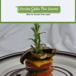 A vegetable stack with a fresh stem of rosemary sticking out the top, surrounded by a swirl of balsamic glaze.