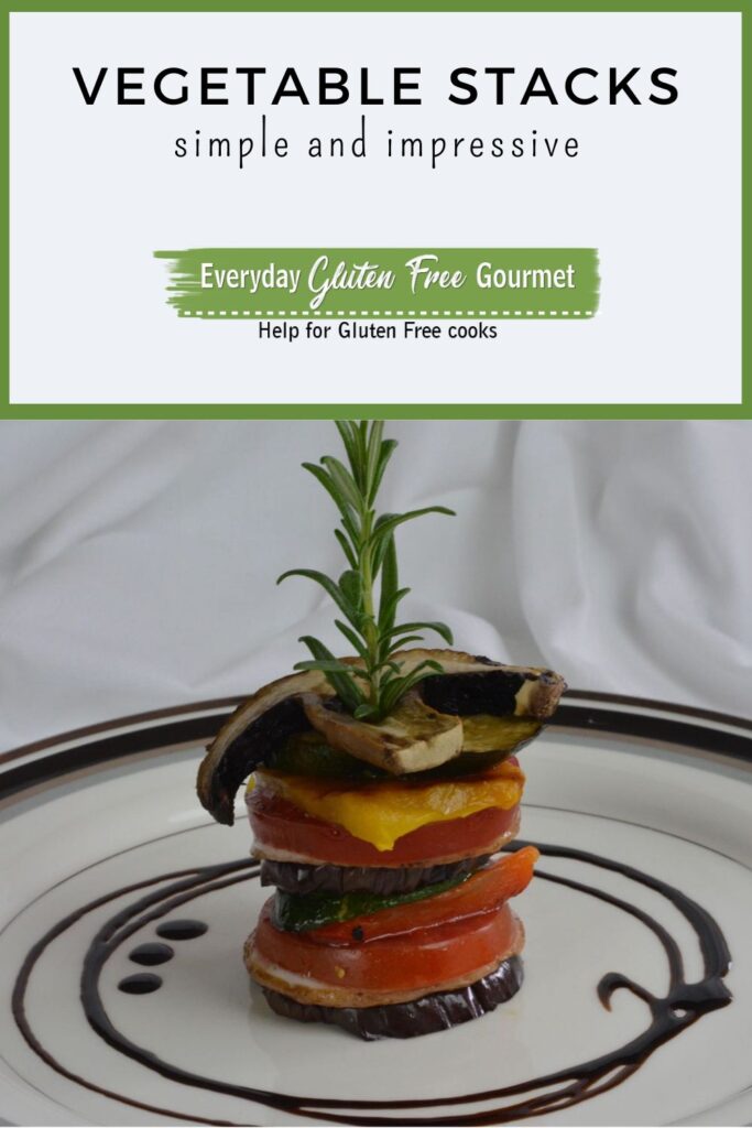 A vegetable stack with a fresh stem of rosemary sticking out the top, surrounded by a swirl of balsamic glaze.