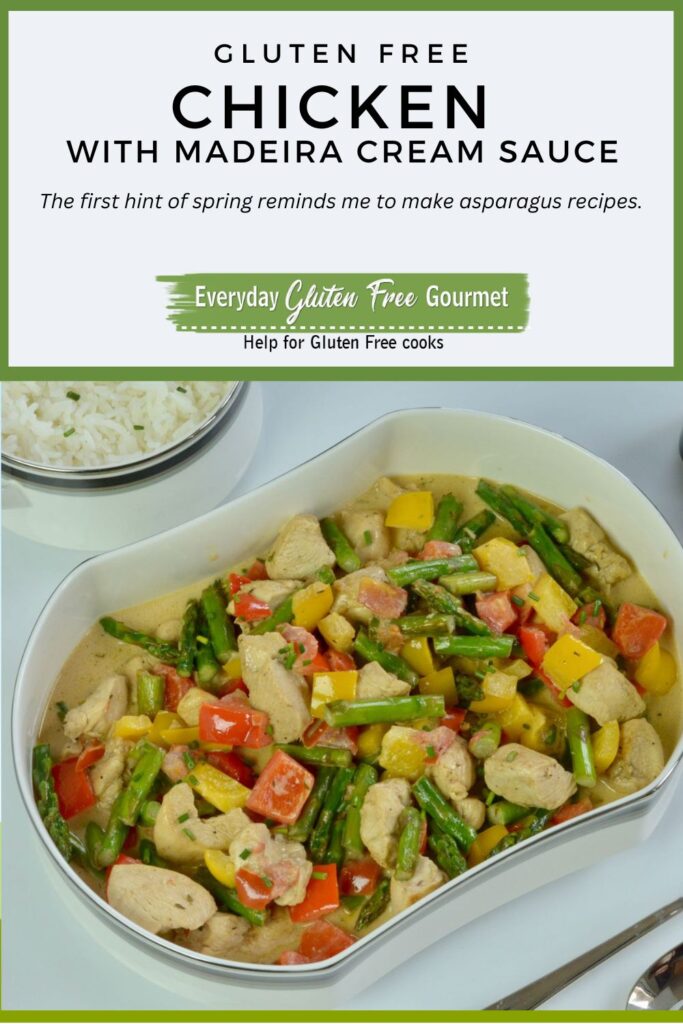 A serving dish of Chicken in Madeira Cream Sauce with asparagus, red and yellow peppers plus a side dish of rice.