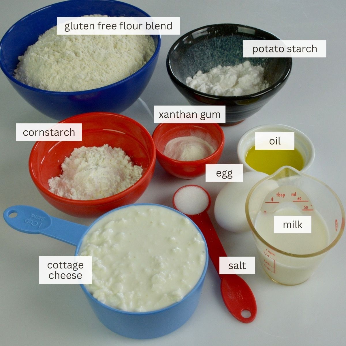 Bowls and spoons showing all the ingredients for this gluten free perogy dough recipe.