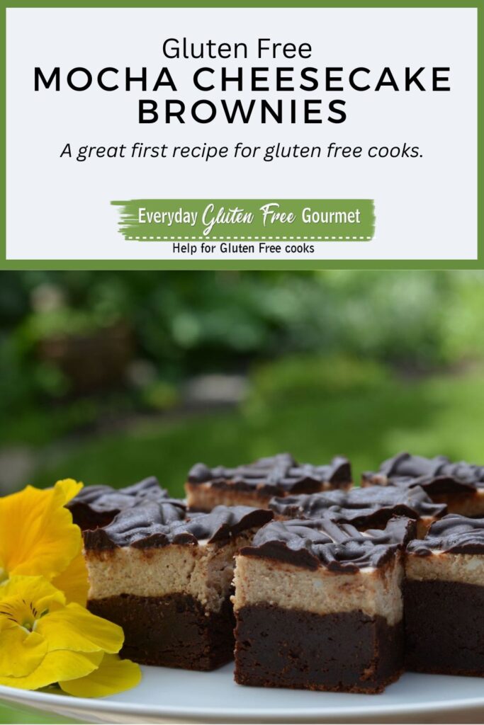 A pedestal tray with gluten free Mocha Cheesecake Brownies decorated with pansies.