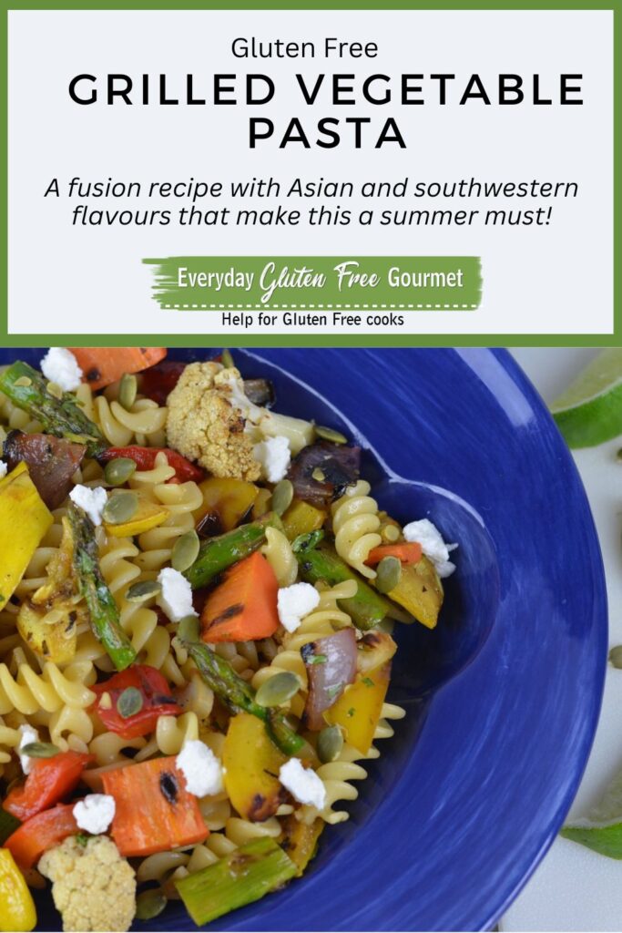 A bowl of gluten free Grilled Vegetable Pasta topped with goat cheese and pumpkin seeds.