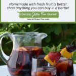 A sunny outdoor table with a pitcher plus two glasses of Prosecco Berry Sangria garnished with fresh fruit.