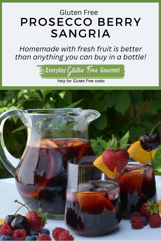 A sunny outdoor table with a pitcher plus two glasses of Prosecco Berry Sangria garnished with fresh fruit.