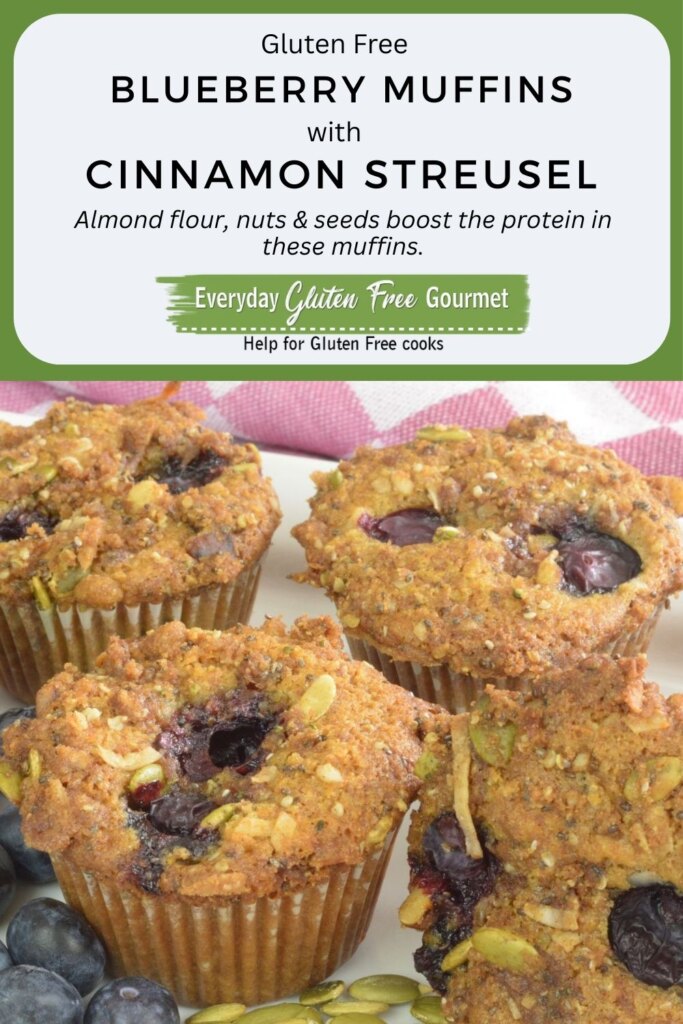 Gluten free Blueberry Muffins surrounded by fresh blueberries and pumpkin seeds.