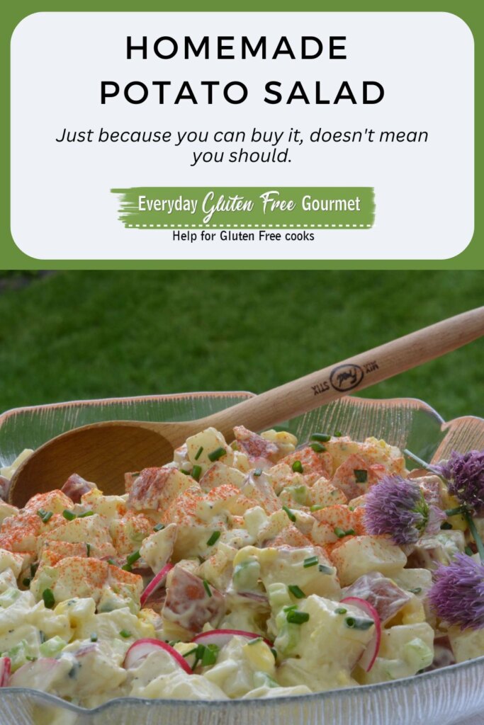 A bowl of homemade Potato Salad with radish slices, snipped chives, a sprinkling of paprika and a few chive blossoms.