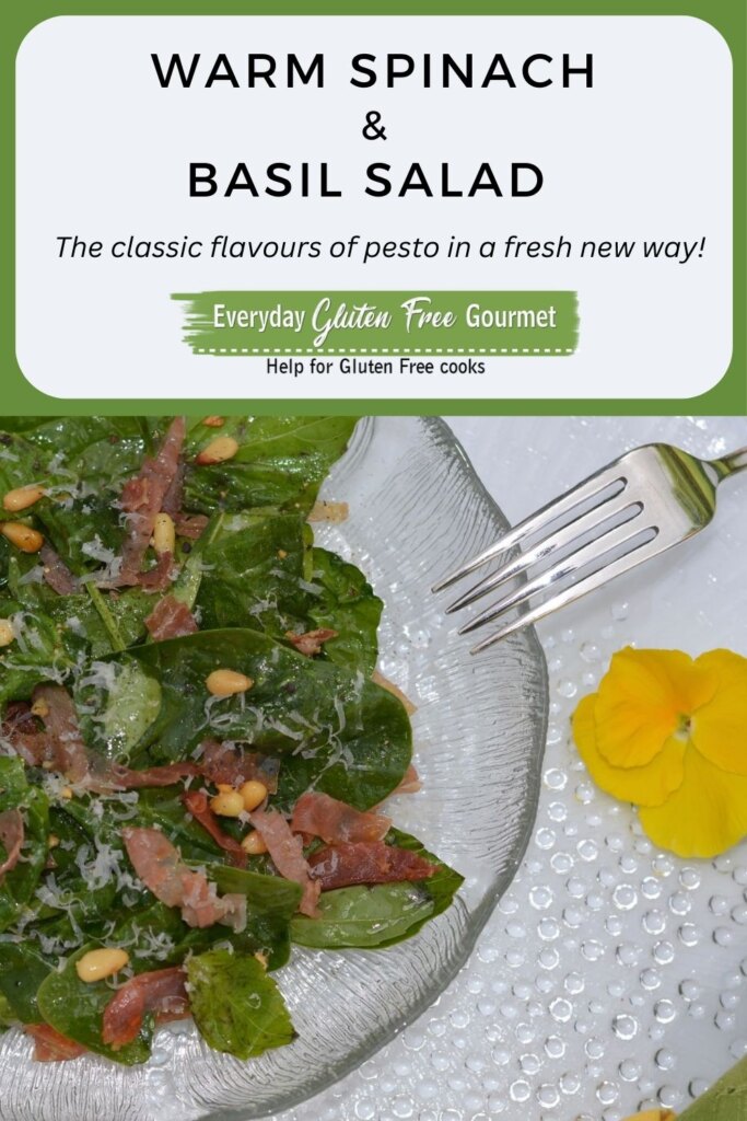 A Warm Spinach Basil Salad on a plate with pine nuts and frizzled prosciutto.