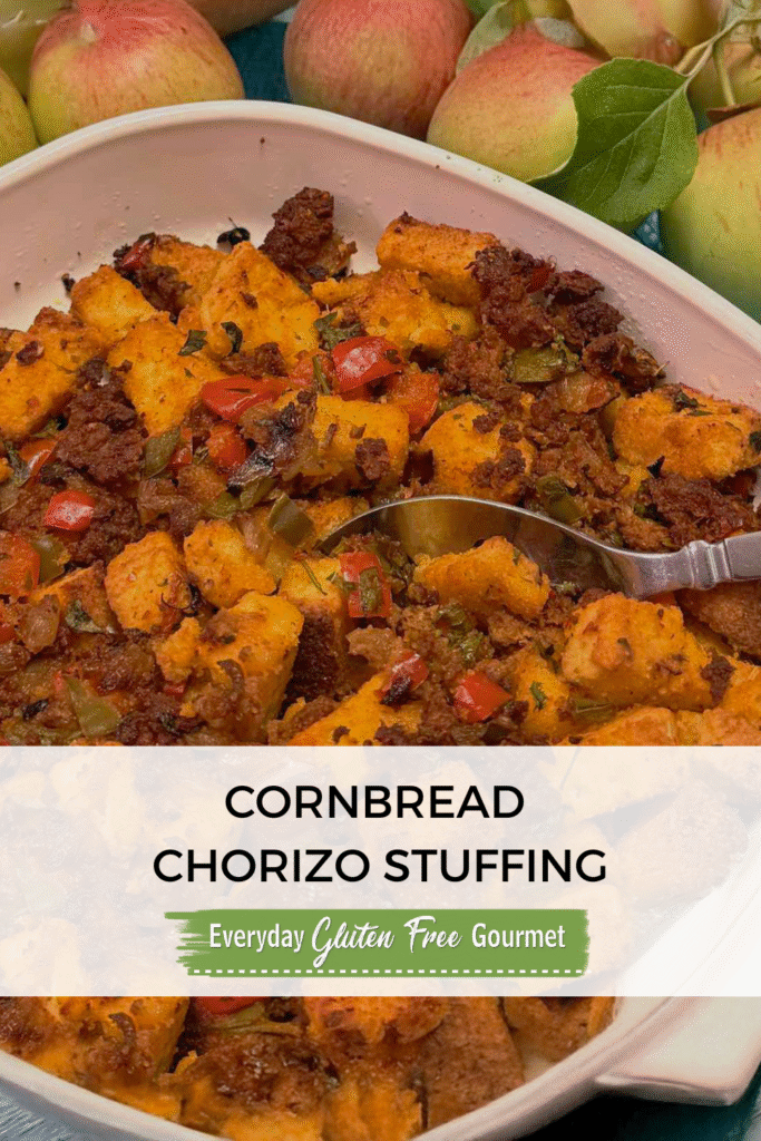 A casserole dish of gluten free Cornbread Chorizo Stuffing surrounded by apples.