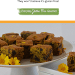 Cut pieces of Pumpkin Date Cake on a pedestal tray garnished with edible flowers and surrounded my mini pumpkins.