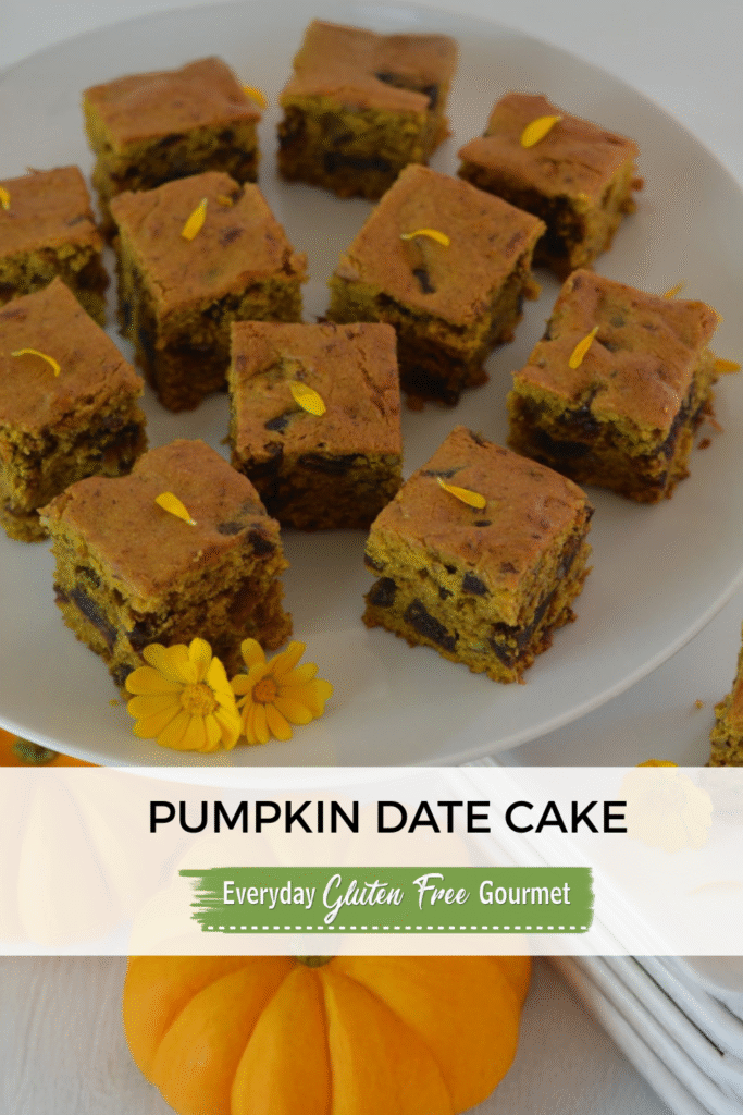 Cut pieces of Pumpkin Date Cake on a pedestal tray garnished with edible flowers and surrounded my mini pumpkins.