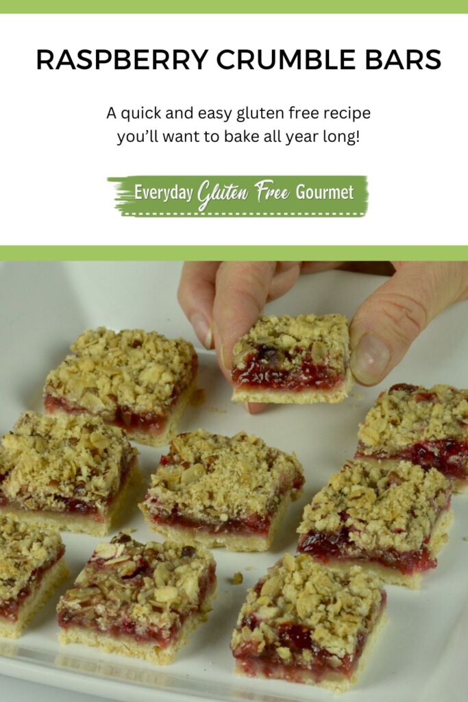 Someone taking a piece from a tray of gluten free Raspberry Crumble Bars.