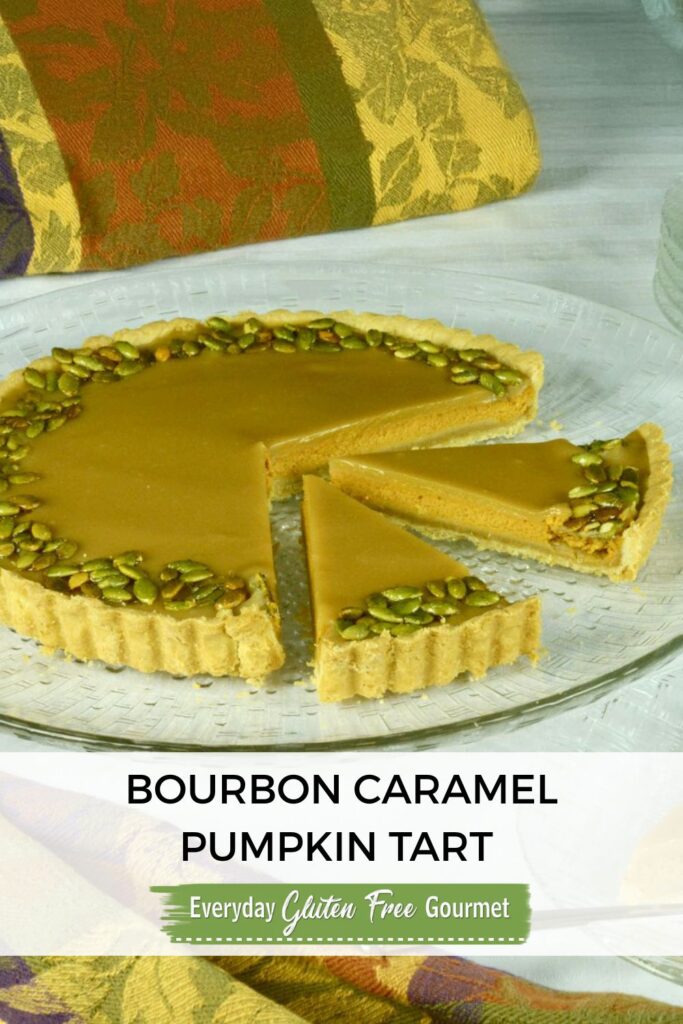 A gluten free Bourbon Caramel Pumpkin Tart on a platter with two pieces cut.