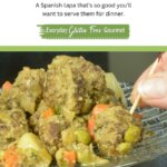 A plate of Spanish Meatballs in Almond Sauce with a hand grabbing one with a toothpick.