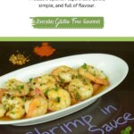 White plate with shrimp in garlic sauce sprinkled with parsley, in the background is garlic, chile flakes and paprika.