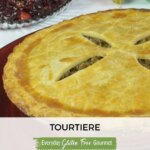 A whole tourtiere on a red platter with a dish of cranberry chutney and a few Christmas balls.